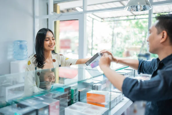 Erkek Dükkan Sahibinin Yardımıyla Güzel Bir Müşteri Seçiyor — Stok fotoğraf
