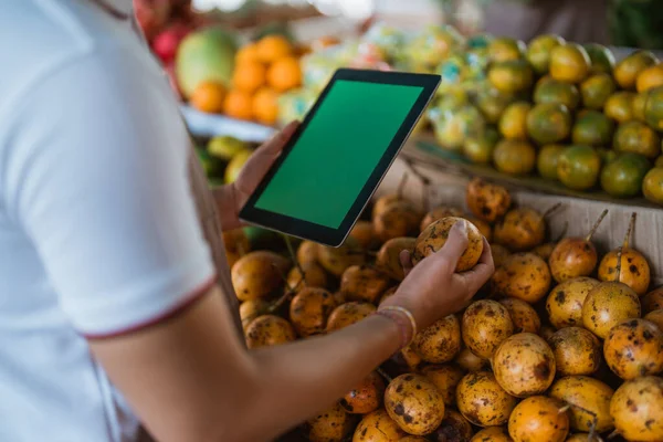 Erkek Meyve Satıcısı Tutku Meyvesini Kontrol Ederken Dijital Tableti Yeşil — Stok fotoğraf