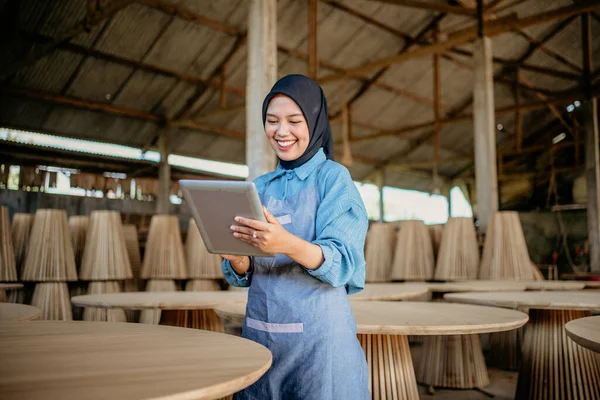 stock image young businesswoman in veil standing using a tablet to work in wood craft shop