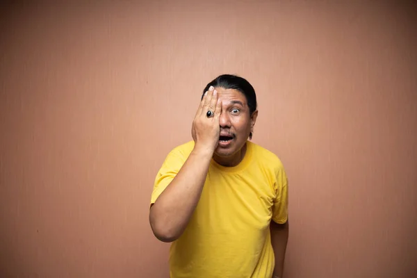 Oude Aziatische Man Dragen Geel Tshirt Bedekken Zijn Halve Ogen — Stockfoto