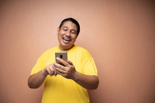 Starý Asijský Muž Sobě Žluté Tričko Drží Telefon Používá Jej — Stock fotografie