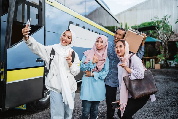穆斯林家庭坐在巴士站上等着与父母一起乘公共汽车度假的肖像 走之前先要自理 — 图库照片