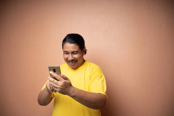 Sarı Tişört Giyen Yaşlı Asyalı Bir Adam Cep Telefonu Tutuyor — Stok fotoğraf