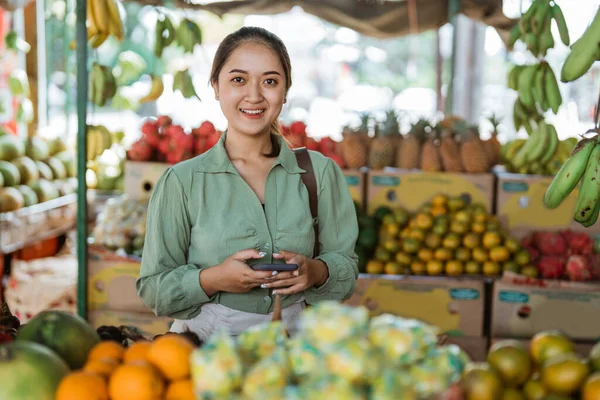 Kobieta Klient Uśmiecha Się Stojąc Trzymając Telefon Sklepie Owocami — Zdjęcie stockowe