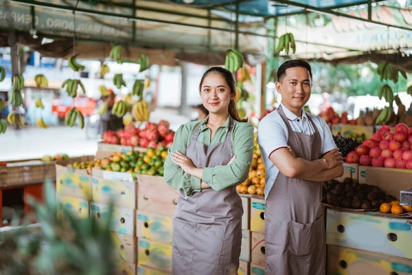 Een Paar Fruitverkopers Met Schort Samen Met Handgekruiste Vruchten Achtergrond — Stockfoto