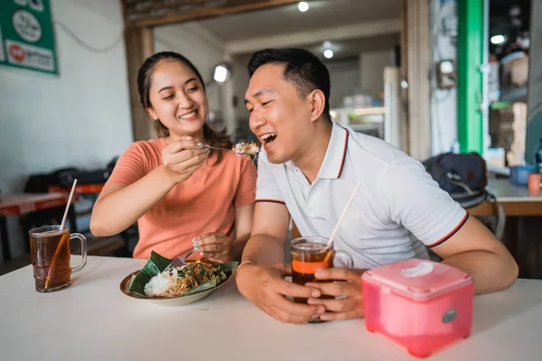 女の子はスプーンで彼氏にご飯を食べながらご飯を食べさせ — ストック写真