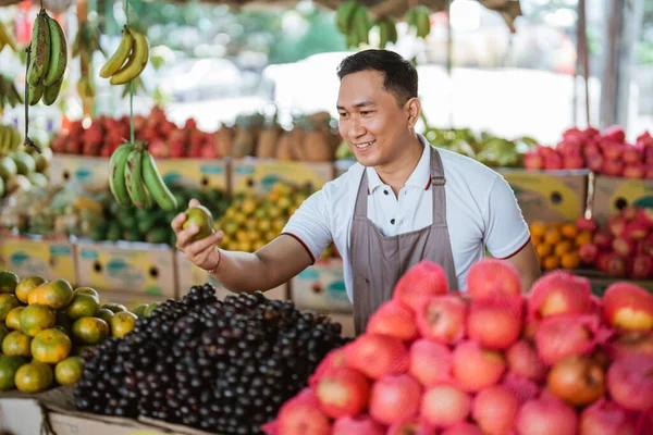 Męski Sprzedawca Owoców Uśmiechnięty Przy Wyborze Pomarańczy Sklepie Owocami — Zdjęcie stockowe