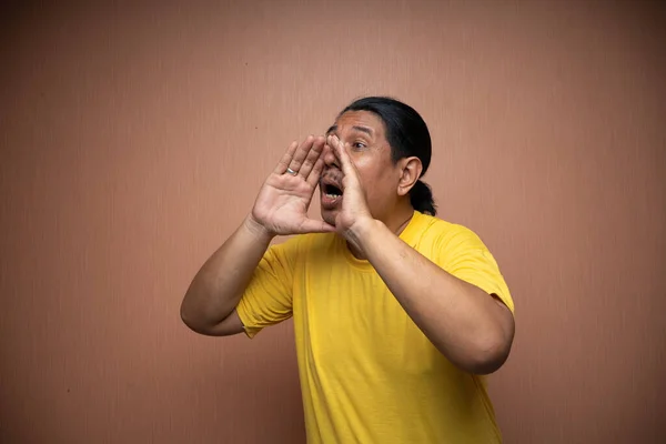 Alter Asiatischer Mann Gelbem Shirt Mit Schreiender Geste Für Ankündigung — Stockfoto