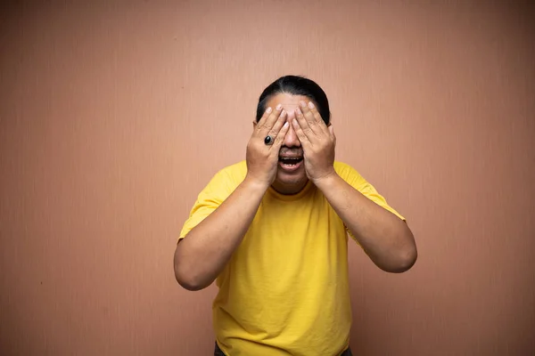 Viejo Asiático Hombre Usando Amarillo Camiseta Cubriendo Cara Porque Sensación —  Fotos de Stock