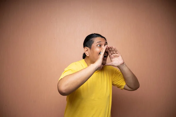 Alter Asiatischer Mann Gelbem Shirt Mit Schreiender Geste Für Ankündigung — Stockfoto
