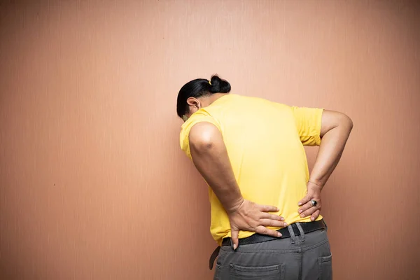 背中の痛みに苦しむアジア系の老人の背中のジェスチャーを — ストック写真