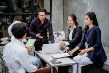 Takım çalışması ve genç bir iş adamı bir açık hava toplantısında beyin fırtınası, işbirliği ya da işbirliği yapıyor.
