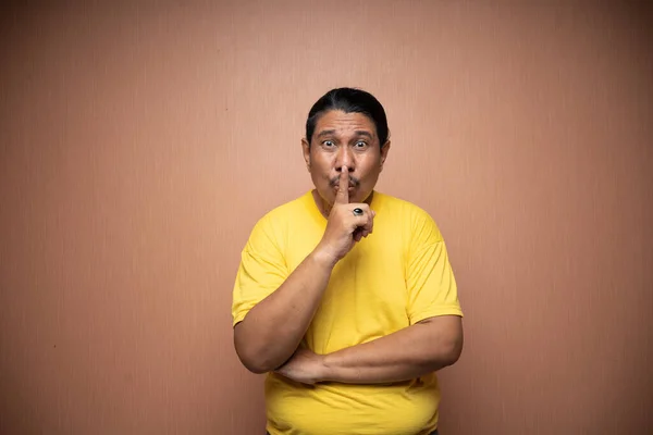 Old Asian Man Wearing Yellow Tshirt Quiet Shush Gesture Plain — Stock Photo, Image