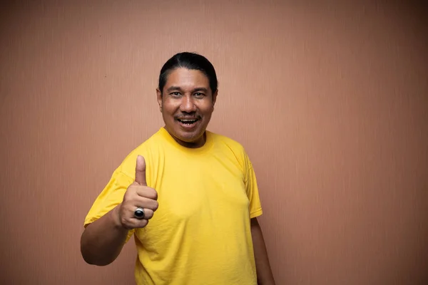 Alter Asiatischer Mann Gelbem Shirt Mit Daumen Hoch Geste Die — Stockfoto