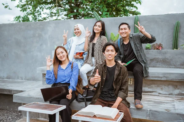 Grupo Estudiantes Asiáticos Sonríen Cámara Mientras Están Sentados Juntos Fuera — Foto de Stock