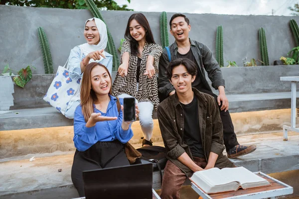 Grupp Glada Studenter Visar Kamerans Telefonskärm Medan Sitter Med Vänner — Stockfoto