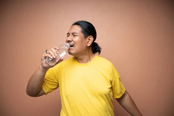 Old Asian Man Holding Drinking Unlabelled Plastic Bottle Plain Background — Stock Photo, Image