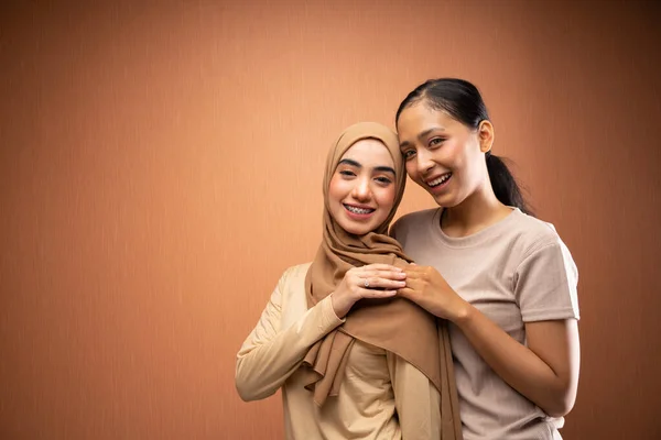 Mujeres Felices Hijab Hijab Usando Camiseta Crema Abrazándose Sonriendo Fondo — Foto de Stock
