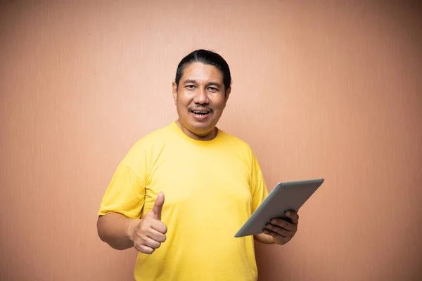 Yaşlı Asyalı Adam Tableti Sol Eliyle Tutuyor Arka Planda Baş — Stok fotoğraf