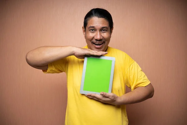Old Asian Man Wearing Yellow Tshirt Holding Tablet Showing Camera — Stock Photo, Image