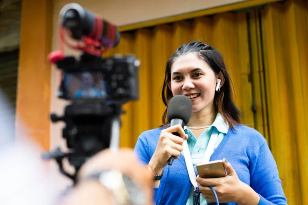 Mavi Hırkalı Bir Kadın Muhabir Video Çekimi Sırasında Kameraya Konuşuyor — Stok fotoğraf