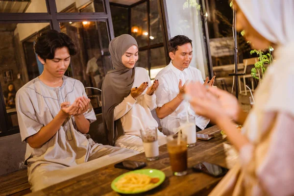 イスラム教徒の友人のグループが一緒に祈る屋外ディナーを楽しむ前に — ストック写真