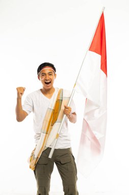 Beyaz tişörtlü yakışıklı bir Asyalı ve omuz kemeri dimdik duran bir sarong kolunda Endonezya bayrağı olan bir sopa getirip gülümsedi.