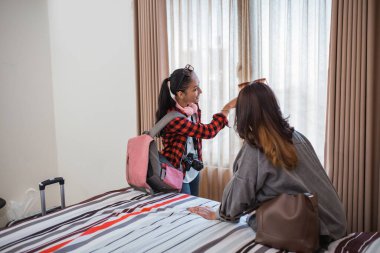 İki Asyalı kadın bir otel odasının penceresinden bir şeye bakıyorlar.