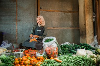 Çiftçi pazarında sebze tezgahında çalışan mutlu Asyalı satıcının potraniti.