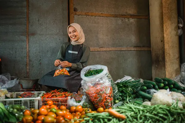 happy greengrocery seller working in vegetable stall in farmer market
