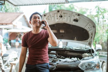 Yakışıklı tamirci bir atölye molasında cep telefonu görüşmesi yapıyor.