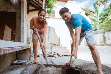Genç bir çift boş zamanlarını ev yapmak için çimento karışımı yaparak geçirir.