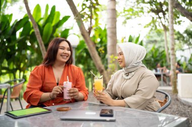 İş kadını bir kafede oturuyor ve bir kafede iş arkadaşıyla sohbet ediyor.