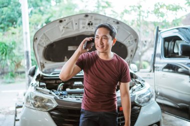 Yakışıklı tamirci bir atölye molasında cep telefonu görüşmesi yapıyor.