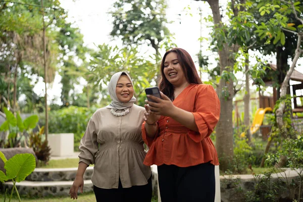 Kadını Telefonunu Tutarak Tesettürcüye Mutlu Bir Ifadeyle Gösteriyor — Stok fotoğraf