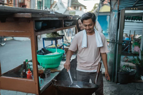hardworking man stirring hot wok cooking fried rice, oriental food