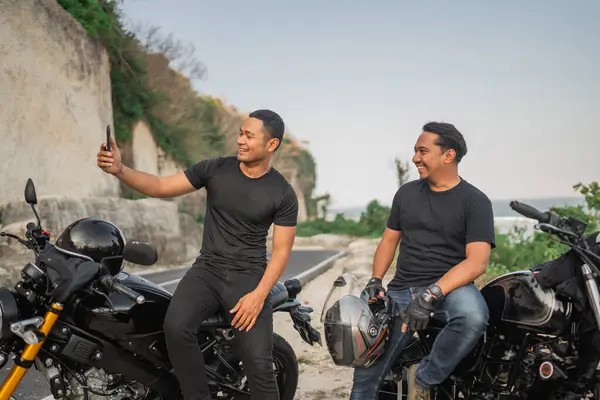 バイクに座って一緒に写真を撮るアジア人男性の側面 — ストック写真