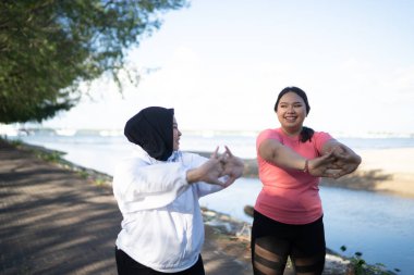 İki kadın egzersizden önce ısınıyor ya da ısınıyor.
