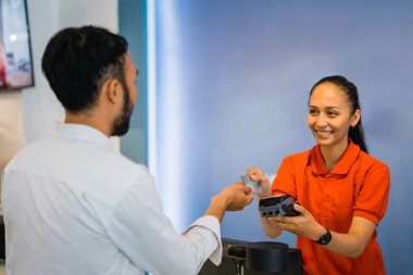 Alış-veriş yapan kişi kredi kartıyla ödeme yaparken bir mobilya mağazasında EDC cihazı olan bir tezgahtar tarafından servis ediliyor.