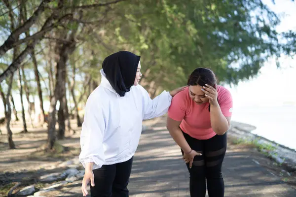 Başörtülü Kadın Koşuyor Yorgun Arkadaşına Yardım Ediyor Sağlıklı Aktivite Konsepti — Stok fotoğraf