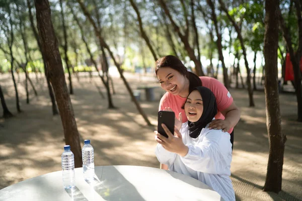 Spor Giyimli Asyalı Kadınlar Ellerinde Telefonla Fotoğraf Çekiyorlar — Stok fotoğraf