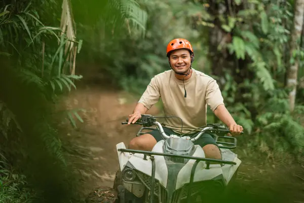 Feliz Asiático Homem Sorrindo Para Câmera Enquanto Equitação Atv Através Imagens Royalty-Free