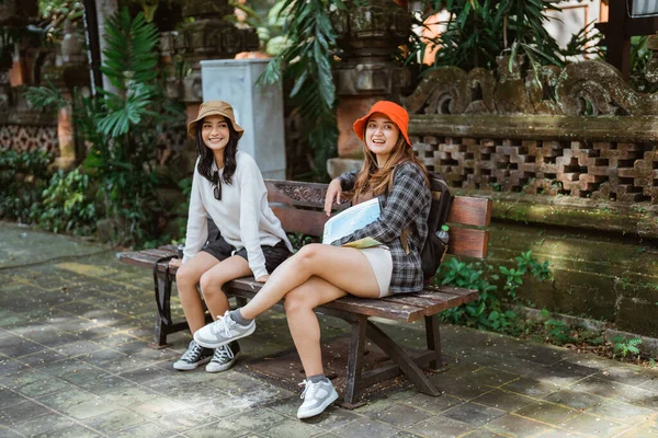 観光スポットで散歩した後 座っている2人の魅力的な女性の肖像画 ロイヤリティフリーのストック写真
