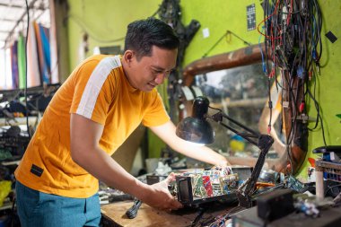 Tamirci, tamirat sırasında elektronik aletleri lambanın altına yerleştirir.