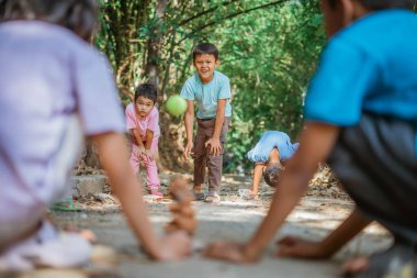 Genç çocuk kırsalda geleneksel oyunlar oynarken eğleniyor.