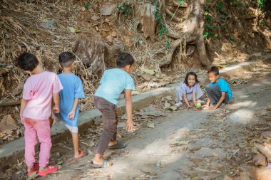 Endonezyalı çocuklar kırsalda arkadaşlarıyla oyun oynuyorlar.