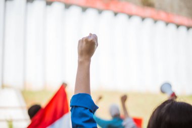 Tutkulu bireyler dayanışma içinde birleşiyor, hareketli ve maksatlı bir protesto sırasında yumruklarını kaldırıyor.