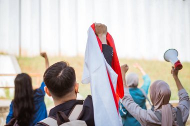 Gençlik aktivistleri renkli bayraklar ve değişim için megafonla tutkuyla gösteri yapıyorlar.