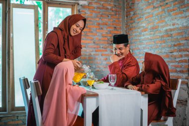 Müslüman kadın iftar sırasında kocasına ve kızına içki dolduruyor.