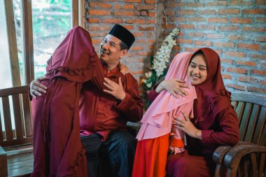 Kurban Bayramı 'nda Asyalı Müslüman ailenin evde kucaklaşması.